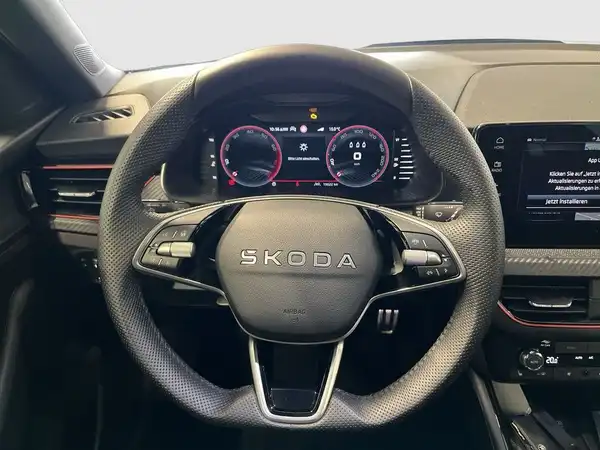 Das Bild zeigt das Innenraum des ŠKODA KAMIQ. Es ist eine Aufnahme des Lenkrads mit digitalen Anzeigen. Die Innenfarbe ist schwarz.