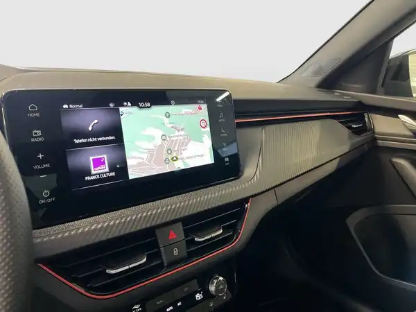 Das Bild zeigt den Innenraum eines ŠKODA KAMIQ mit einem Fokus auf das Navigationssystem und der Mittelkonsole.