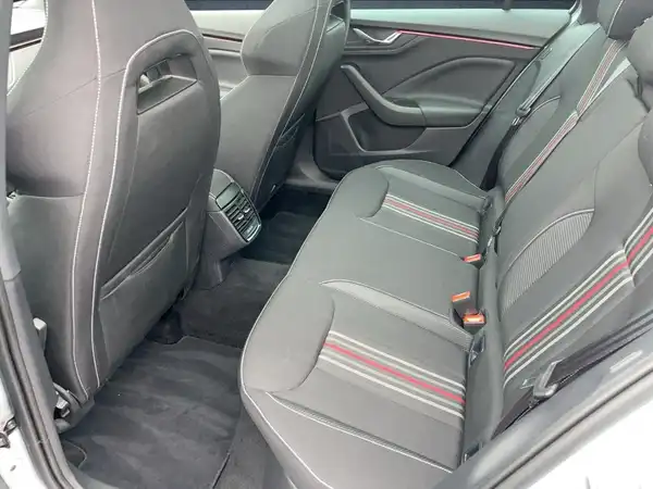 Das Bild zeigt den Innenraum des Fahrzeugs von hinten, mit schwarzen Sitzen und roten Akzenten.
