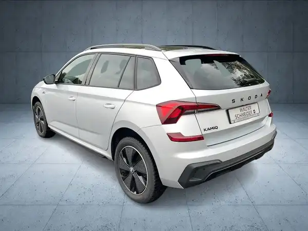 Das Bild zeigt einen weißen ŠKODA KAMIQ, aufgenommen von hinten.