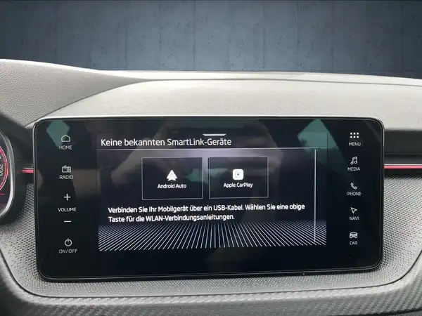 Das Bild zeigt das Innenraumdisplay eines ŠKODA KAMIQ. Es handelt sich um eine Innenaufnahme mit einem schwarzen Interieur. Es sind markante Texteinblendungen zu sehen, die Informationen zu SmartLink-Geräten und App-Verbindungen enthalten.