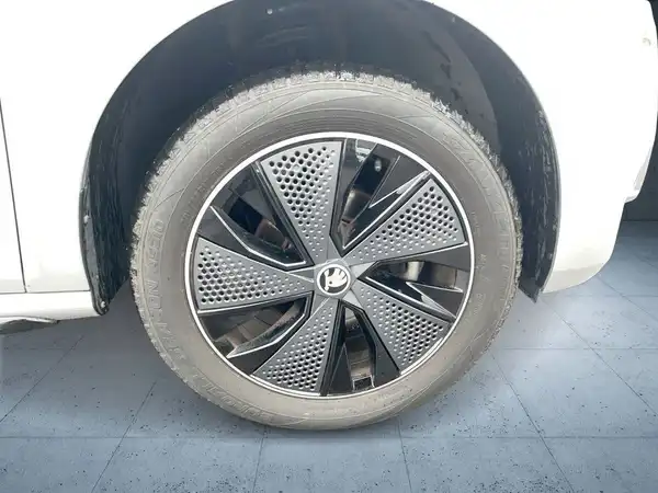Das Bild zeigt das Rad eines weißen ŠKODA KAMIQ aus der Seitenansicht.