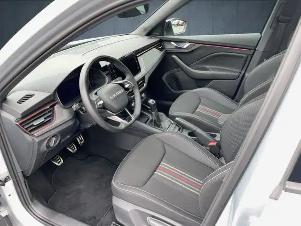 Innenaufnahme des ŠKODA KAMIQ mit schwarzen Sitzen und roten Akzenten.