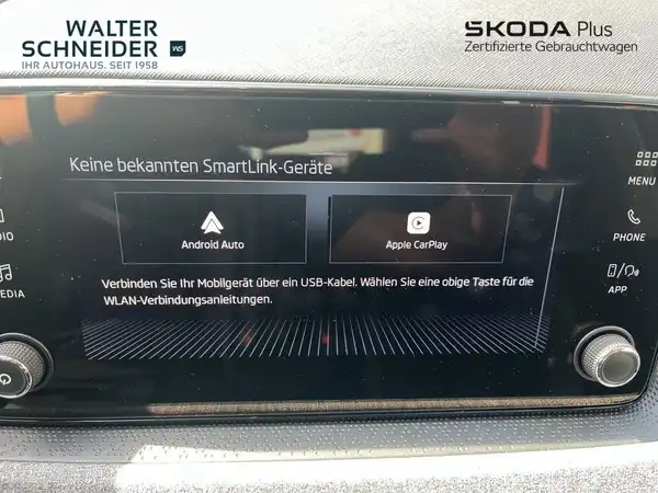 Das Bild zeigt den Innenraum eines ŠKODA KAMIQ mit einem Display, das keine bekannten SmartLink-Geräte anzeigt. Das Interieur ist schwarz. Im Bild ist das Händlerlogo von Walter Schneider eingeblendet.