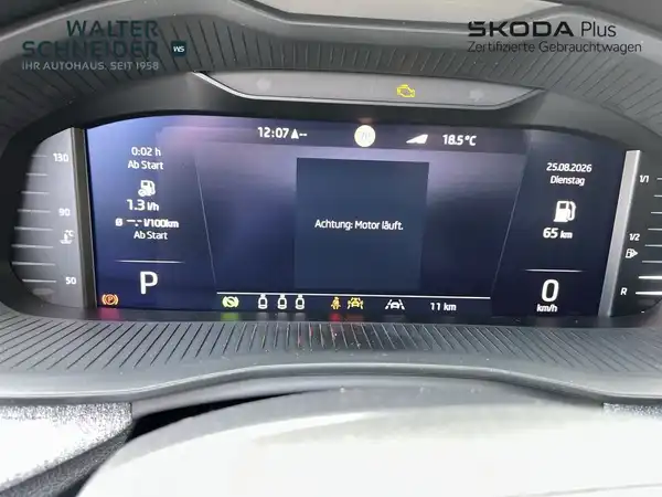 Innenaufnahme des Fahrzeugs, schwarzes Interieur. Das Bild zeigt das Navigationsdisplay mit verschiedenen Informationen über das Fahrzeug. Das Händlerinformationen sind oben links und rechts sichtbar.