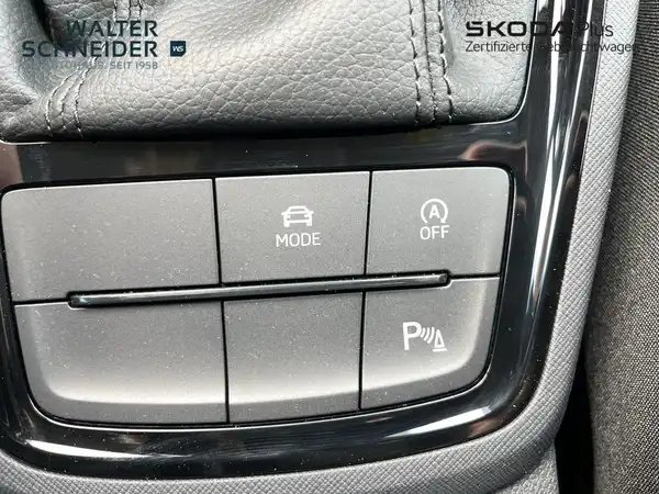 Das Bild zeigt eine Innenaufnahme des ŠKODA KAMIQ, speziell den Bereich mit Knöpfen auf dem Armaturenbrett in schwarzer Farbe.