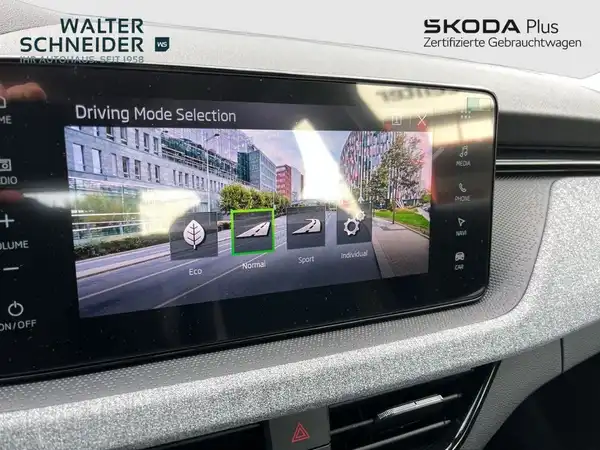 Das Bild zeigt das Innenraum eines ŠKODA KAMIQ mit einem digitalen Display, das die Auswahl des Fahrmodus anzeigt. Das Interieur ist in schwarzer, glänzender Ausführung gehalten. Das Händlerlogo "WALTER SCHNEIDER" ist im Bild zu sehen.