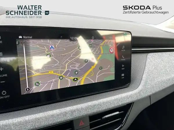 Das Bild zeigt den Innenraum eines ŠKODA KAMIQ mit einem Navigationsgerät in grauer Farbgestaltung. Im Hintergrund ist das Händlerlogo von Walter Schneider sichtbar.