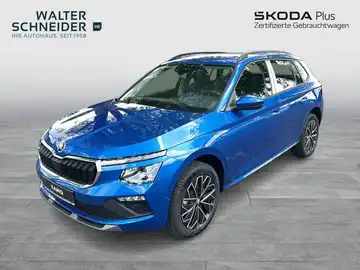 Das Bild zeigt einen blauen ŠKODA KAMIQ von der Seite, mit Händlerinformationen im Hintergrund.