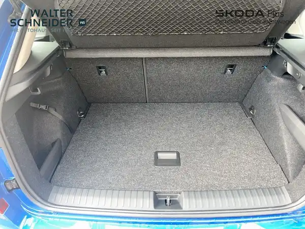 Das Bild zeigt den Kofferraum eines blauen ŠKODA KAMIQ aus der Innenansicht.