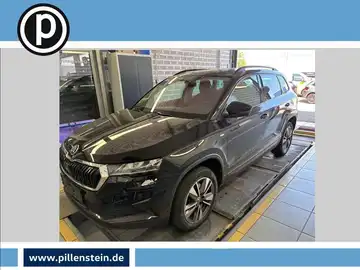 Das Bild zeigt einen ŠKODA KAROQ von der Seite, in schwarzer Farbe. Das Händlerlogo ist im Bild enthalten, ebenso wie markante Texteinblendungen.