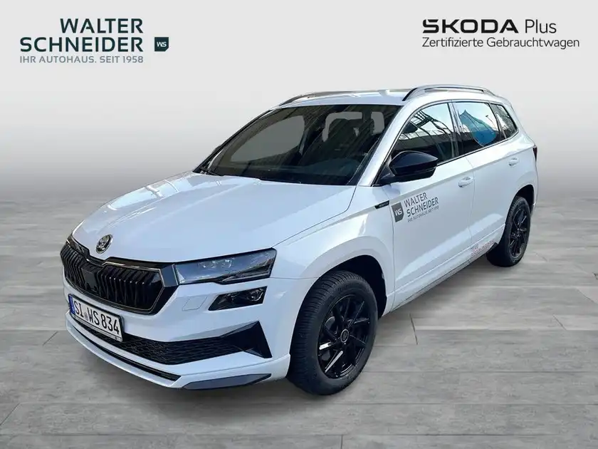 Das Bild zeigt einen weißen ŠKODA KAROQ aus der Frontansicht. Es enthält das Händelerslogo von Walter Schneider und zusätzliche Texteinblendungen.