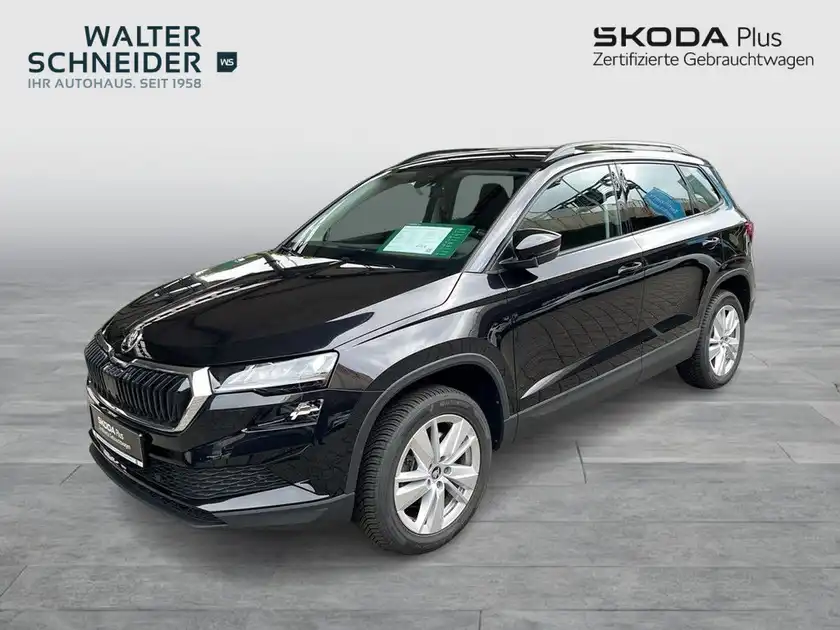 Ein schwarzer ŠKODA KAROQ von der Seite abgebildet. Das Bild enthält Händlerlogo und markante Texteinblendungen.
