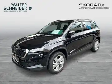 Ein schwarzer ŠKODA KAROQ von der Seite abgebildet. Das Bild enthält Händlerlogo und markante Texteinblendungen.