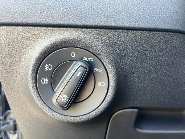 Das Bild zeigt einen Innenraum des Fahrzeugs, konkret einen Schalter für die Scheinwerfer, der in schwarzer Farbe gehalten ist.