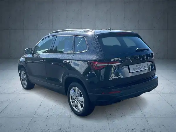 Das Bild zeigt einen schwarzen ŠKODA KAROQ von hinten aufgenommen.