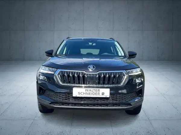 Das Bild zeigt einen schwarzen ŠKODA KAROQ aus der Frontalansicht, mit dem Händlerlogo 'WALTER SCHNEIDER' prominent eingeblendet.