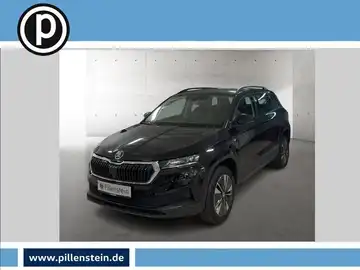 Das Bild zeigt einen schwarzen ŠKODA KAROQ, aufgenommen von vorne. Im Bild ist das Händlerlogo abgebildet.