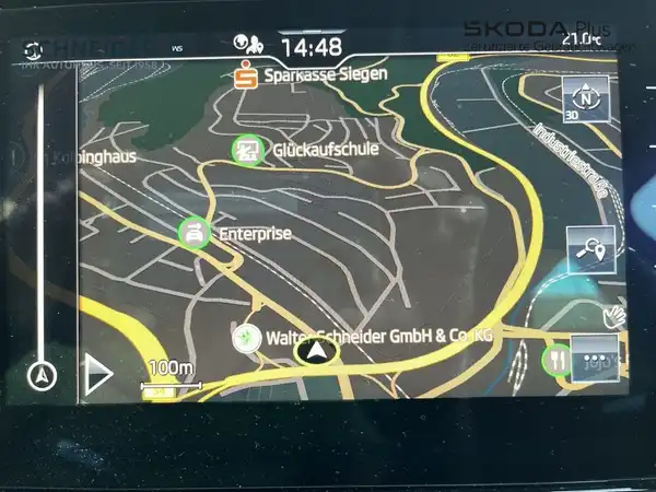 Das Bild zeigt eine Innenaufnahme des Fahrzeugs, spezifisch das Navigationsgerät mit einer Kartenansicht.