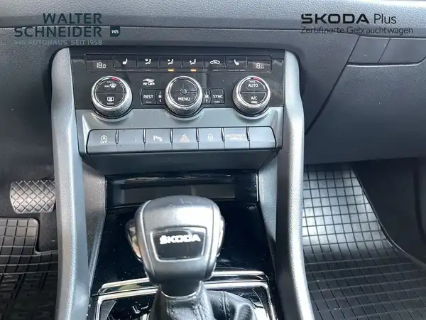 Innenaufnahme des Fahrzeugs, schwarzes Interieur, mit sichtbaren Bedienelementen und Händlerinformationen.