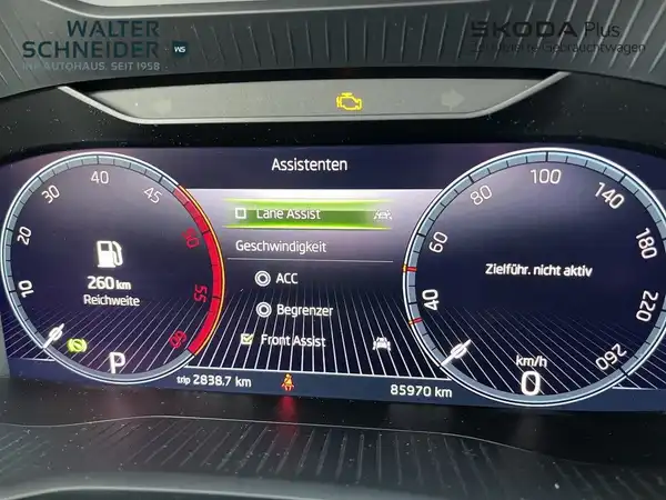 Innenaufnahme eines ŠKODA KODIAQ mit dem schwarzen Interieur und einem digitalen Display der Fahrzeugassistenzsysteme.