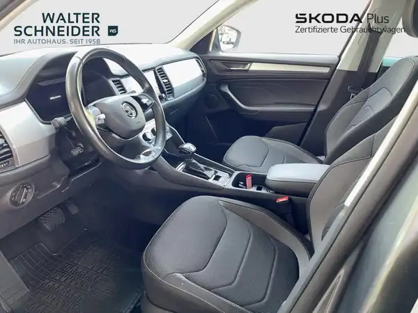 Das Bild zeigt den Innenraum eines ŠKODA KODIAQ in schwarzer Farbgebung, mit einem Händlerlogo im oberen Bereich."