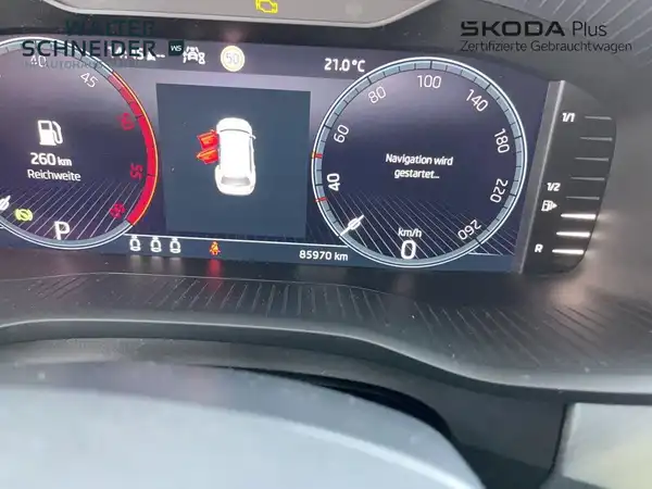 Innenaufnahme eines ŠKODA KODIAQ mit einem Mid-Display, zeigt Navigationshinweis und Instrumententafel.