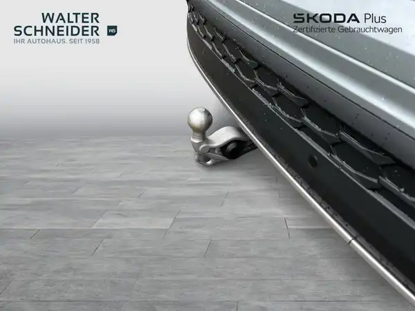 Das Bild zeigt die Frontansicht eines grauen ŠKODA KODIAQ mit einer Anhängerkupplung. Es enthält das Logo des Händlers Walter Schneider und Hinweise auf das Angebot von ŠKODA Plus.