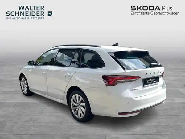Das Bild zeigt einen ŠKODA OCTAVIA in Weiß von der Seite, mit dem Händlerlogo und markanten Texteinblendungen im Hintergrund.