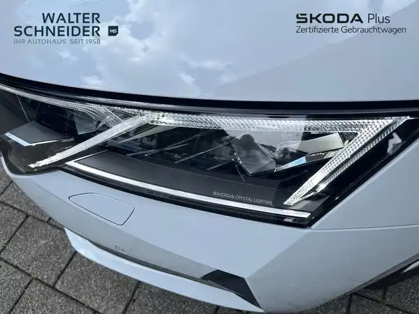 Das Bild zeigt die Vorderansicht eines weißen ŠKODA, mit hervorgehobenen Scheinwerfern und dem Logo des Händlers Walter Schneider.