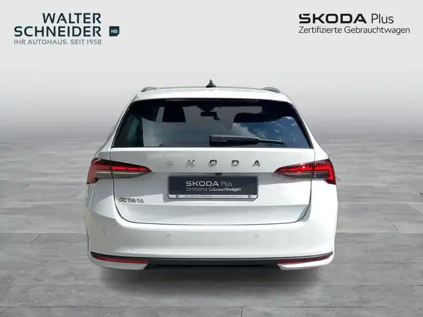 Das Bild zeigt einen weißen ŠKODA OCTAVIA von hinten. Das Händlerinformationslogo und weitere Texteinblendungen sind ebenfalls sichtbar.