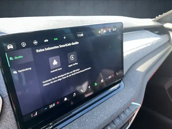 Innenaufnahme des Fahrzeugs mit schwarzem Interieur und einem Bildschirm, der verschiedene Funktionen anzeigt.