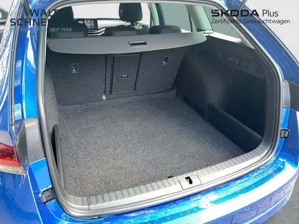 Das Bild zeigt den Innenraum des Kofferraums eines blauen ŠKODA Octavia. Das Händlerlogo ist eingeblendet und es sind markante Texteinblendungen vorhanden.