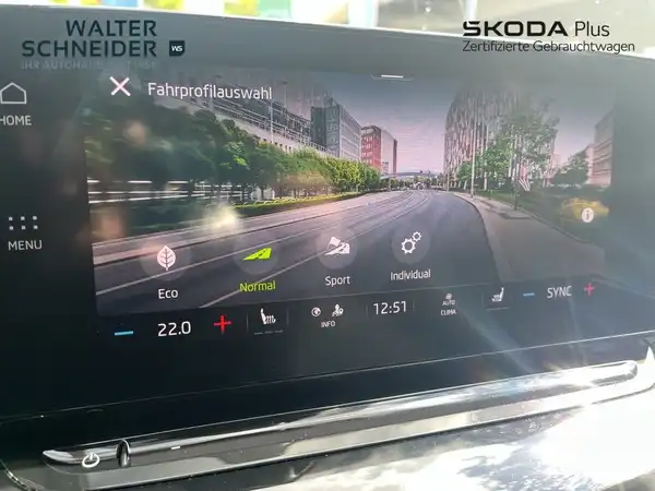 Das Bild zeigt den Innenraum eines ŠKODA OCTAVIA mit einem modernen schwarzen Display, auf dem verschiedene Fahrmodi und Einstellungen angezeigt werden. Zudem ist das Händlerlogo 'WALTER SCHNEIDER' zu sehen.