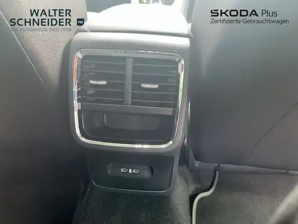 Eine Innenaufnahme des ŠKODA OCTAVIA, die eine schwarze Innenausstattung zeigt, mit Händlerlogos im Bild.