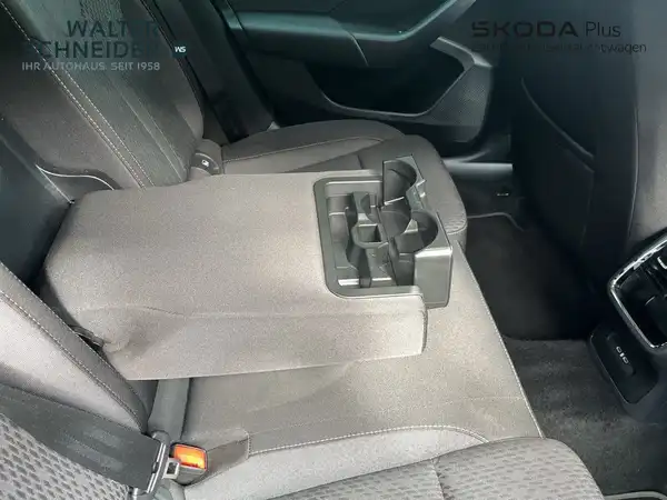 Das Bild zeigt den Innenraum eines ŠKODA OCTAVIA, aufgenommen von der Rücksitze. Die Innenfarbe ist schwarz und enthält markante Texteinblendungen des Händlerlogos.