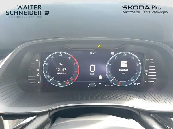 Das Bild zeigt das Armaturenbrett eines ŠKODA OCTAVIA, mit einem digitalen Display in der Mitte. Es handelt sich um eine Innenaufnahme des Fahrzeugs, in einem modernen Design. Das Interieur ist schwarz.