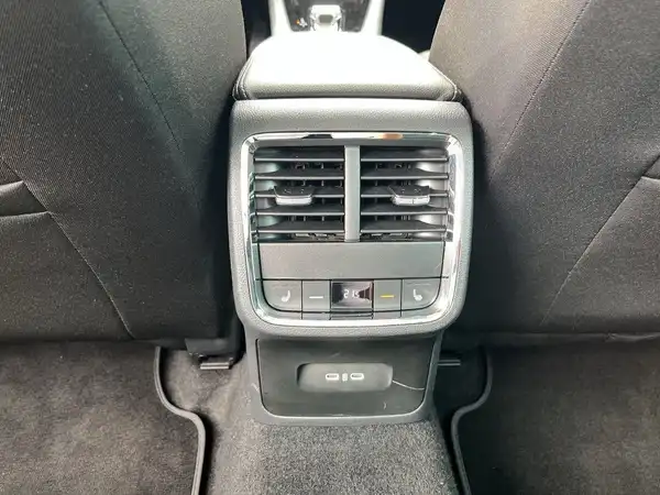 Das Bild zeigt den Innenraum eines Fahrzeugs, mit dem Fokus auf die Klimaanlage und Bedienelemente im Fond. Der Innenraum ist schwarz.