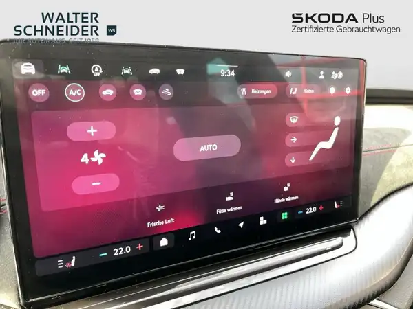 Das Bild zeigt eine Innenaufnahme des Fahrzeugdisplays, in schwarzer Farbe mit diversen Steuerungsanzeigen. Es enthält das Händlerlogo und markante Texteinblendungen.