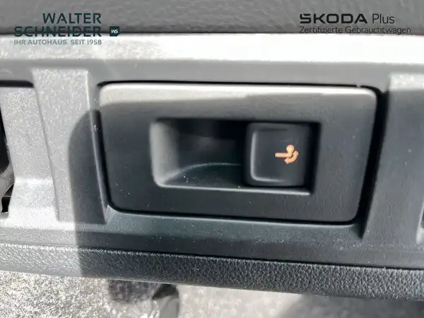 Das Bild zeigt eine Innenaufnahme des Fahrzeugs, konkret einen Schalter oder Knopf im Innenraum. Die Interieurfarbe ist schwarz. Auf dem Foto sind das Händlerlogo und markante Texteinblendungen vorhanden.