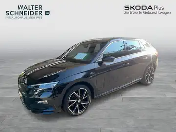 Das Bild zeigt einen schwarzen ŠKODA SCALA aus der Seitenansicht, aufgenommen vor einem Händlerlogo und weiteren markanten Texteinblendungen.