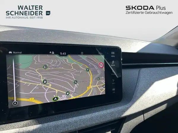 Das Bild zeigt das Innenraumdisplay eines ŠKODA mit einer Navigationskarte. Es gibt Händlerlogos im Bild.
