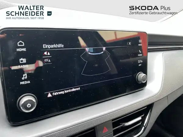 Innenaufnahme eines ŠKODA Fahrzeuges, mit einem schwarzen Interieur und dem Händlerlogo von Walter Schneider sowie weiteren Texteinblendungen.