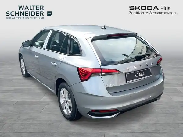 Das Bild zeigt einen ŠKODA SCALA von der Seite in silberner Farbe. Im Hintergrund ist das Händlerlogo von Walter Schneider zu sehen.