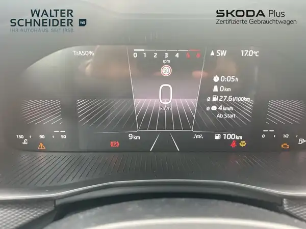 Das Bild zeigt das Cockpit eines ŠKODA-Fahrzeugs, Innenaufnahme mit schwarzem Interieur. Es sind Händlerlogos und markante Texteinblendungen sichtbar.