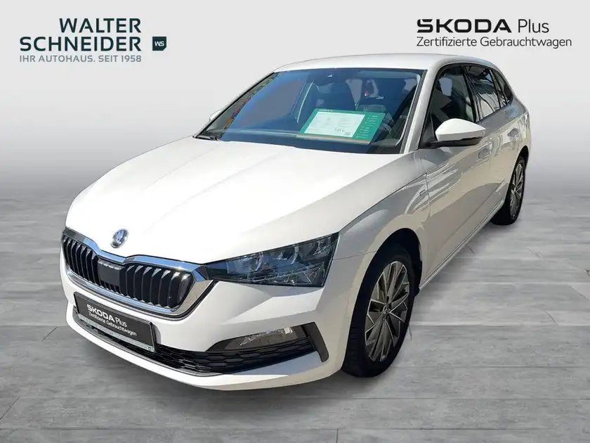 Das Bild zeigt einen weißen ŠKODA SCALA aus der Vorderansicht. Es ist ein Verkaufsbild von einem Händler mit dem Logo und einer markanten Texteinblendung.