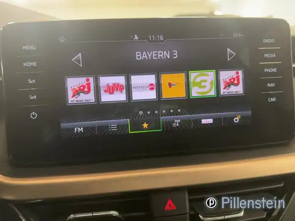 Das Bild zeigt das Interieur des Fahrzeugs einer ŠKODA SCALA, besonders das Multimediadisplay. Es enthält das Händlerlogo und markante Texteinblendungen.