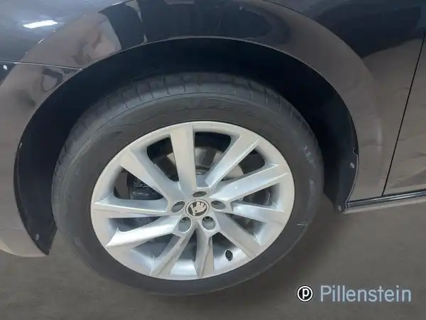 Das Bild zeigt das Rad eines schwarzen ŠKODA SCALA aus der Seitenansicht mit dem Händlerlogo von Pillenstein.