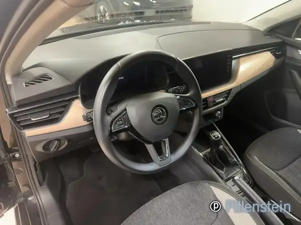 Innenaufnahme eines ŠKODA SCALA mit schwarzem Interieur und Holzdekor.