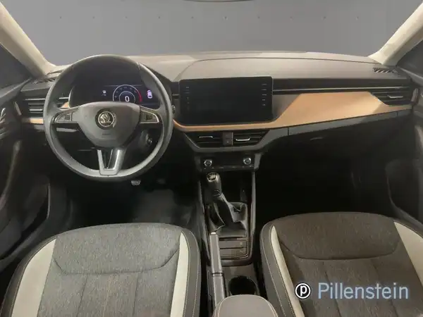Das Bild zeigt das Innere eines ŠKODA SCALA mit grauem Interieur und hellen Akzenten. Es sind Händlerinformationen auf dem Bild sichtbar.